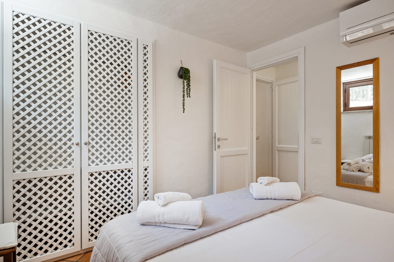 Bedroom with large white wardrobe and balcony door