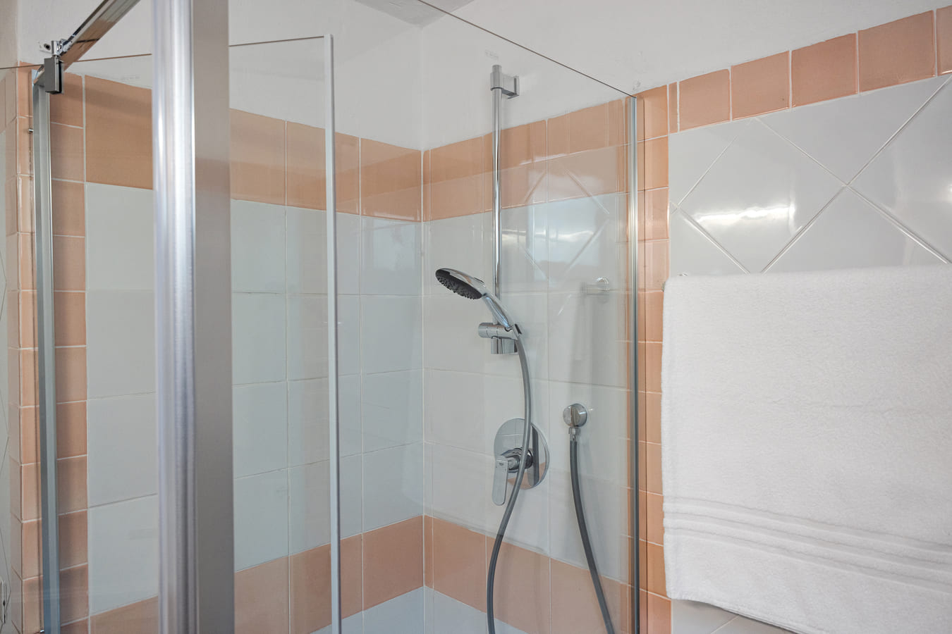 Shower with glass enclosure and tiled walls